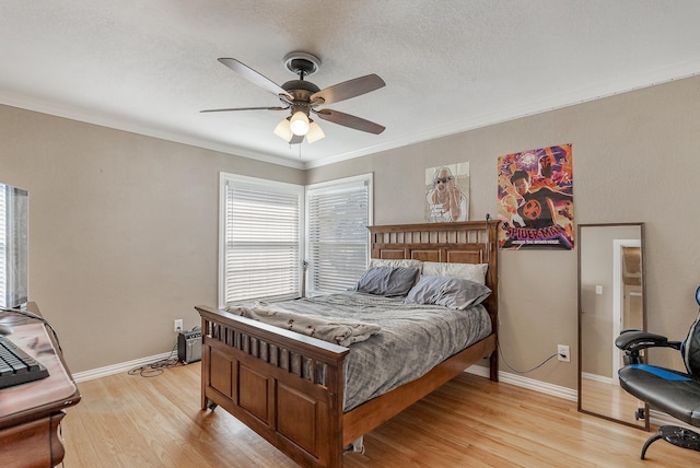 bedroom featuring a textured ceiling, light hardwood / wood-style flooring, ceiling fan, and crown molding