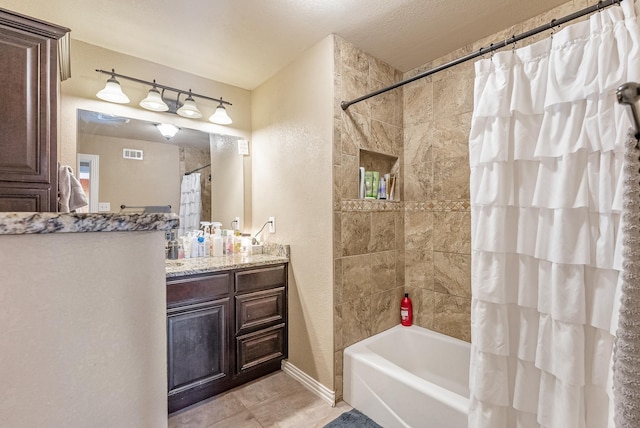 bathroom with tile patterned flooring, shower / bath combination with curtain, and vanity