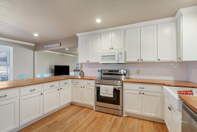 kitchen with white cabinetry, butcher block counters, and appliances with stainless steel finishes