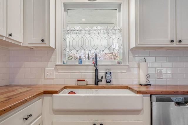 kitchen featuring decorative backsplash, white cabinetry, stainless steel dishwasher, and butcher block counters