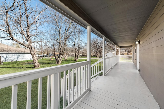 wooden deck with a lawn and covered porch