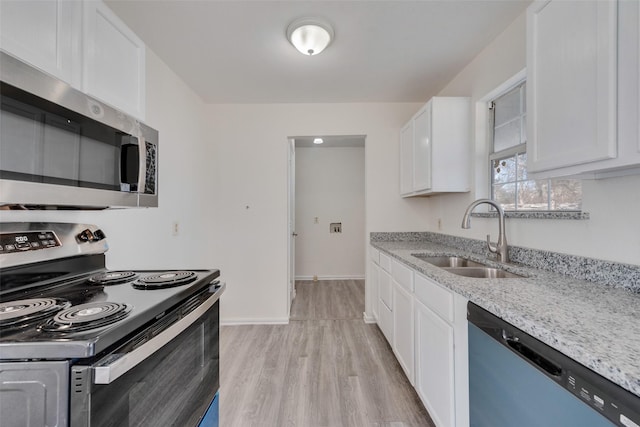 kitchen featuring sink, white cabinets, light stone counters, stainless steel appliances, and light wood-type flooring