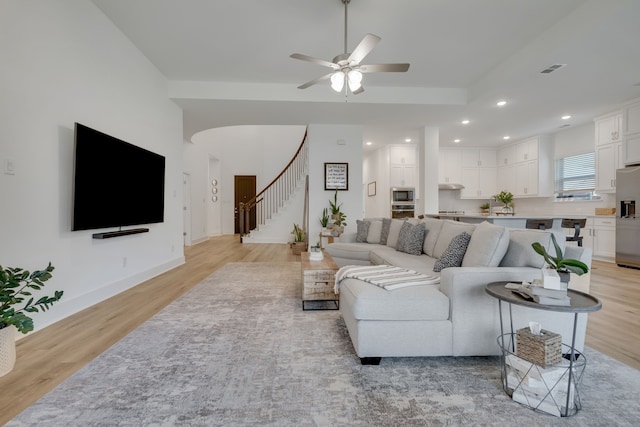 living room with ceiling fan and light wood-type flooring