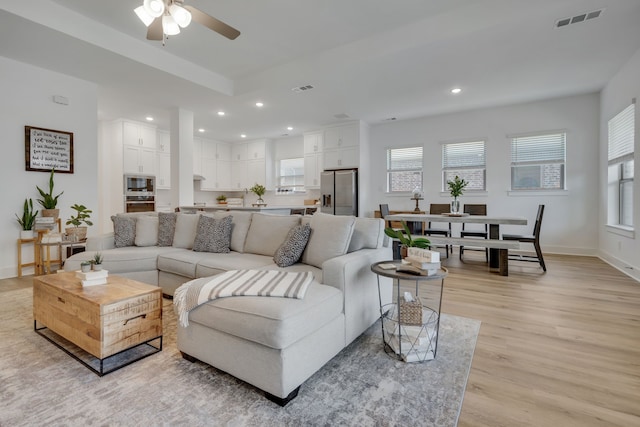 living room with light wood-type flooring and ceiling fan