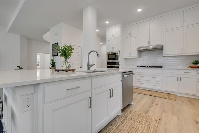 kitchen featuring tasteful backsplash, white cabinets, and stainless steel appliances