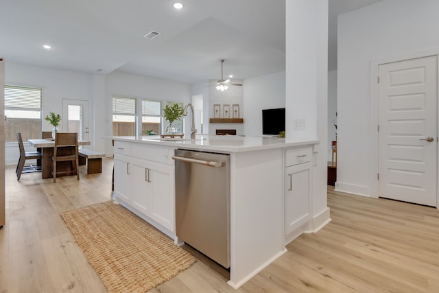 kitchen with dishwasher, white cabinets, ceiling fan, and an island with sink