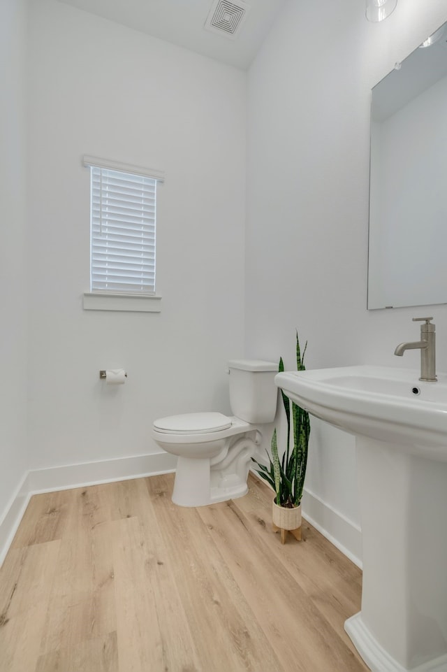 bathroom featuring hardwood / wood-style flooring and toilet