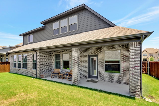 rear view of house with a yard and a patio