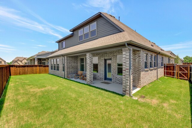 back of house with a lawn and a patio