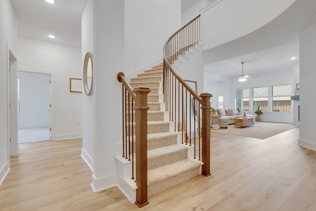 staircase featuring hardwood / wood-style flooring and ceiling fan