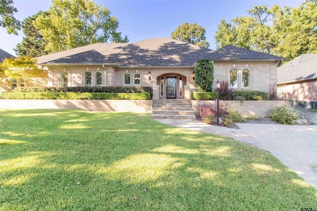 single story home featuring a front lawn