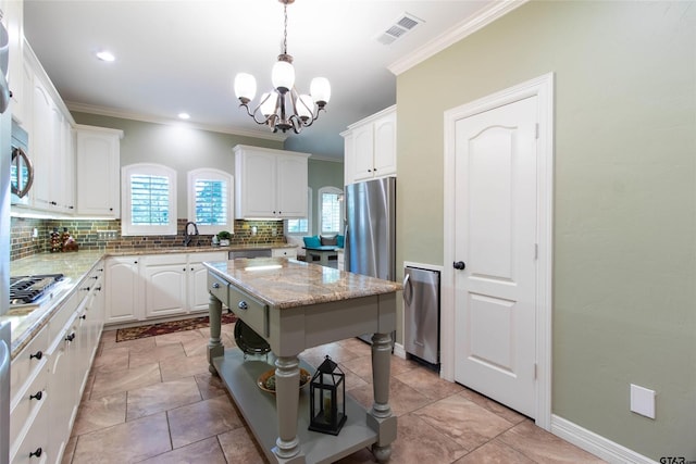 kitchen featuring pendant lighting, a center island, white cabinets, light stone countertops, and stainless steel appliances