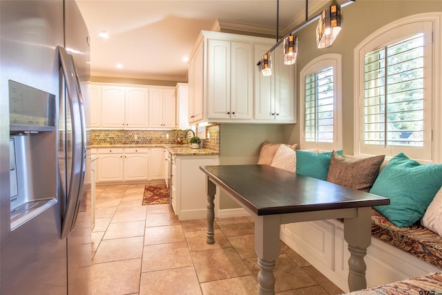 kitchen featuring decorative backsplash, pendant lighting, stone counters, white cabinets, and stainless steel fridge with ice dispenser