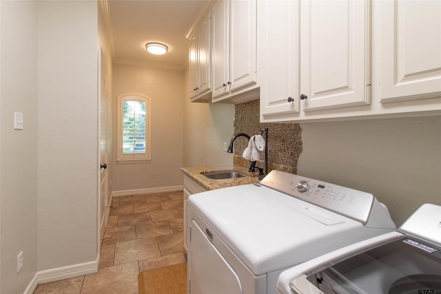 clothes washing area with washer and dryer, cabinets, ornamental molding, and sink