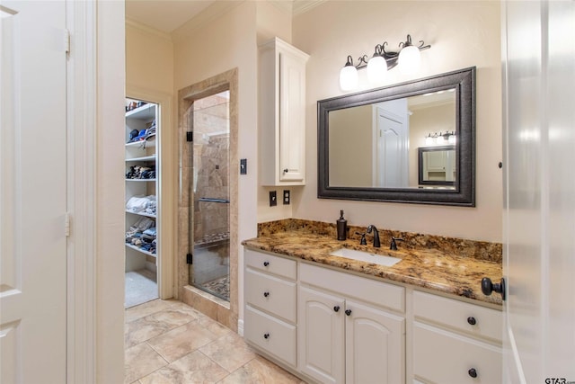 bathroom with crown molding, tile patterned flooring, vanity, and a shower with shower door