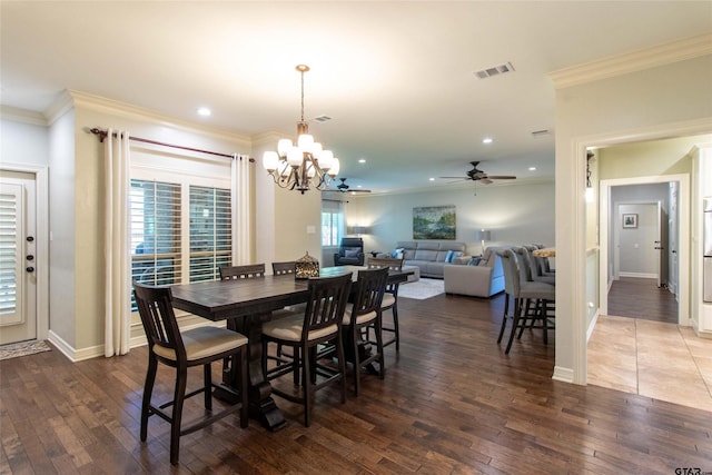 dining room featuring crown molding, dark wood-type flooring, and ceiling fan with notable chandelier