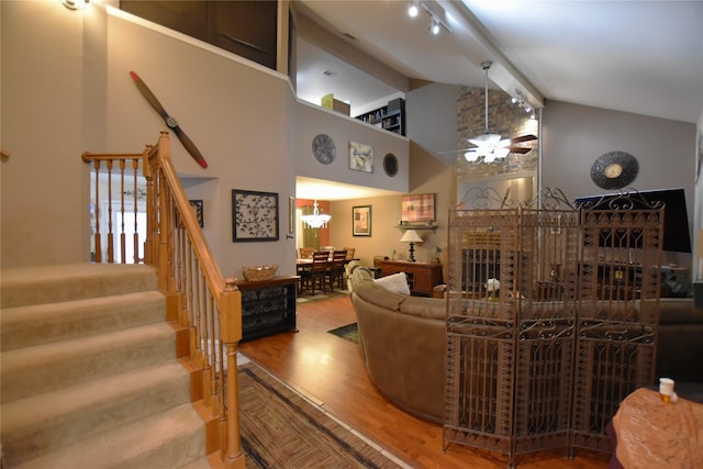 living room with hardwood / wood-style flooring, ceiling fan, beam ceiling, and high vaulted ceiling