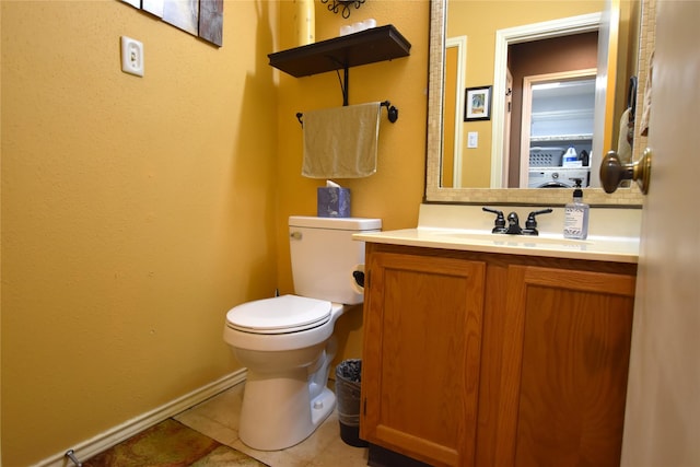 bathroom with tile patterned flooring, vanity, and toilet