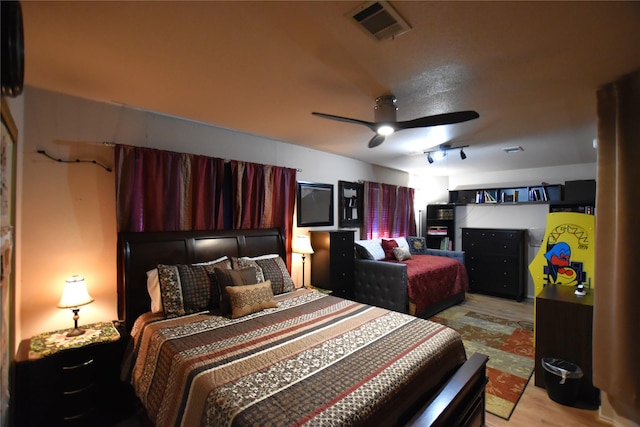 bedroom with ceiling fan, track lighting, and light wood-type flooring