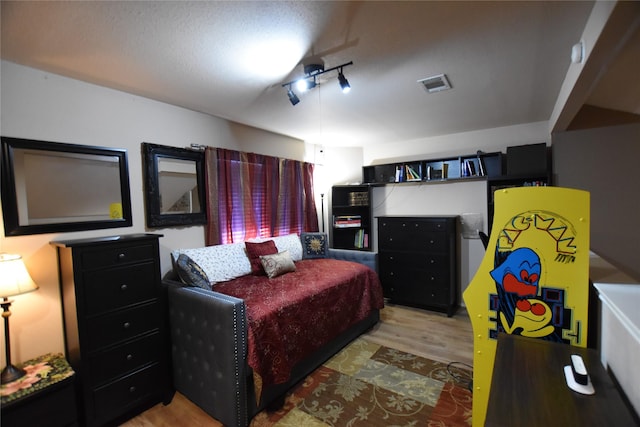 bedroom featuring light wood-type flooring and a textured ceiling