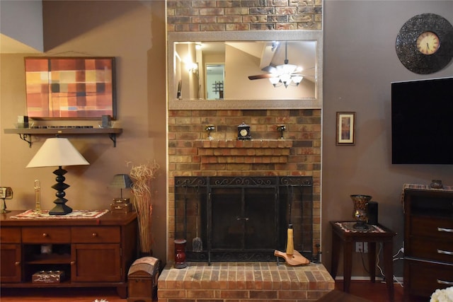 living room featuring a brick fireplace and ceiling fan