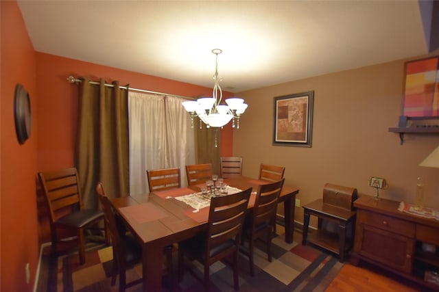 dining room with hardwood / wood-style floors and a chandelier