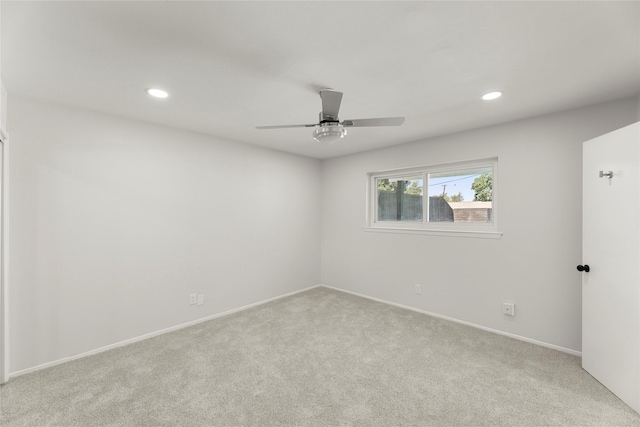 spare room with ceiling fan and light carpet