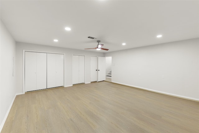 basement featuring ceiling fan and light hardwood / wood-style floors