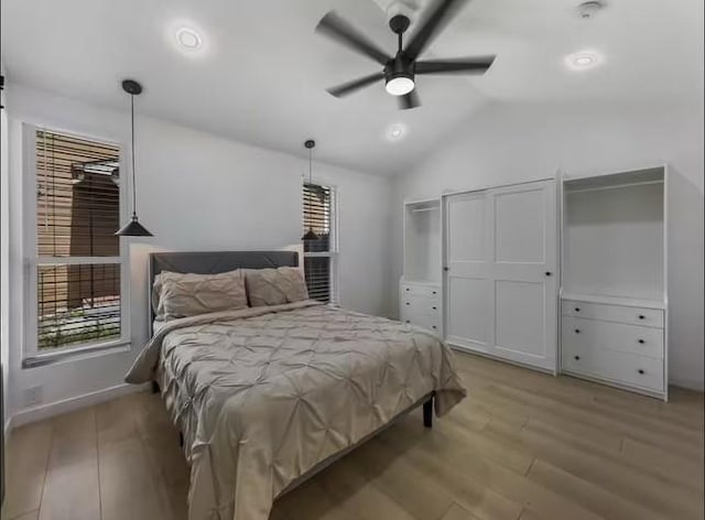 bedroom with ceiling fan, light hardwood / wood-style floors, and lofted ceiling