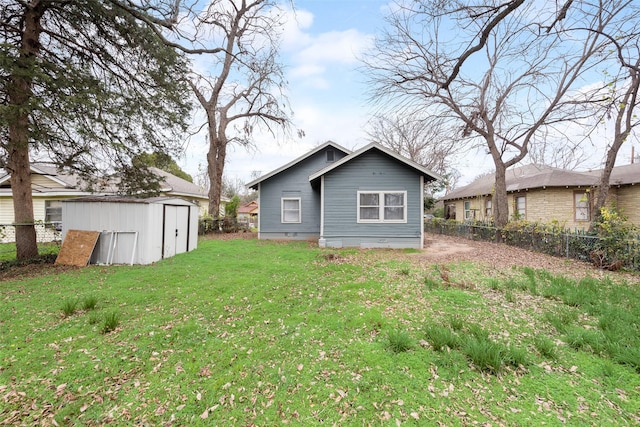 back of house with a storage shed and a lawn