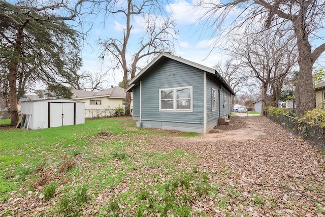 back of property featuring a lawn and a storage unit