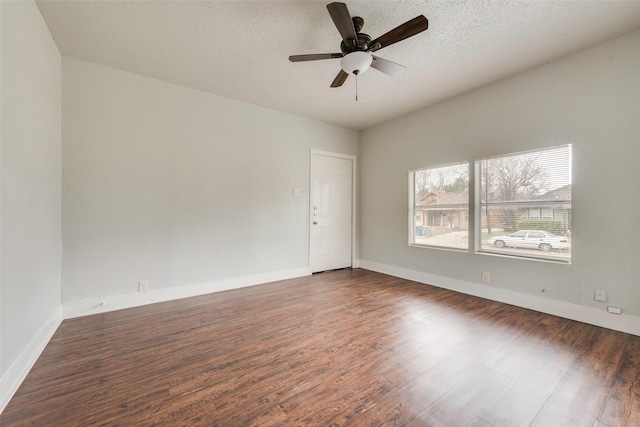 unfurnished room featuring ceiling fan, dark wood-type flooring, and a textured ceiling