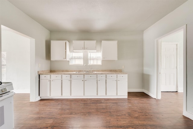 kitchen featuring white electric range oven, white cabinetry, dark wood-type flooring, and sink