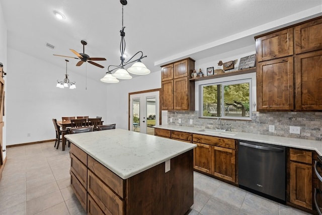 kitchen with pendant lighting, sink, decorative backsplash, a center island, and stainless steel dishwasher