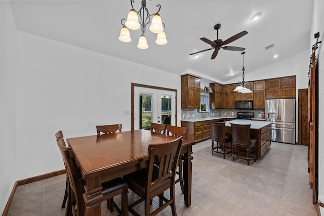 tiled dining area featuring lofted ceiling, ceiling fan with notable chandelier, and french doors