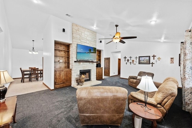 living room featuring high vaulted ceiling, carpet floors, a fireplace, built in shelves, and ceiling fan with notable chandelier