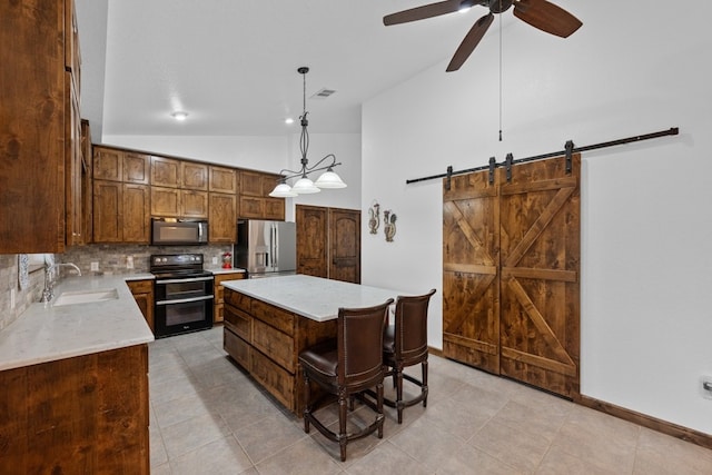 kitchen featuring pendant lighting, sink, stainless steel fridge, a kitchen island, and range with two ovens