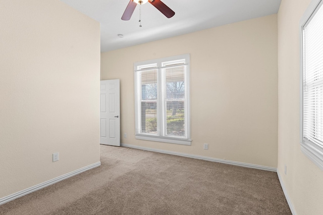 spare room featuring light carpet and ceiling fan