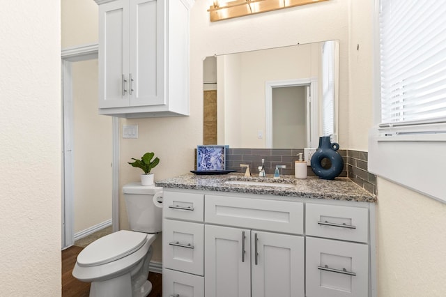 bathroom featuring vanity, wood-type flooring, and toilet