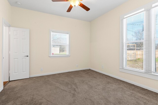 carpeted spare room with ceiling fan