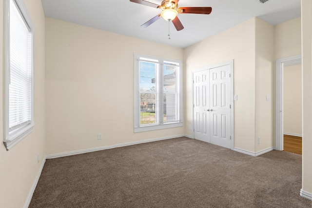 unfurnished bedroom with carpet, a closet, and ceiling fan