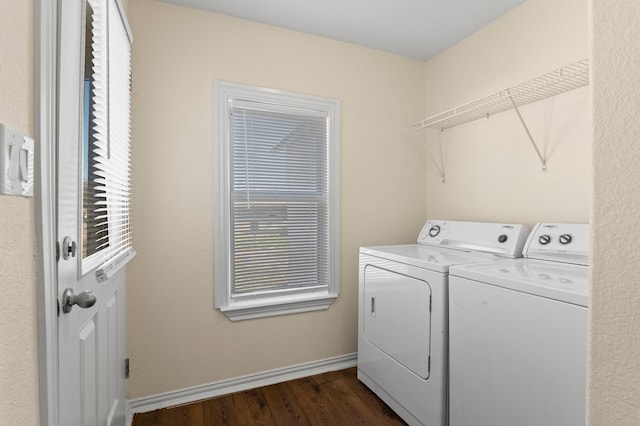 clothes washing area with washing machine and dryer and dark hardwood / wood-style flooring