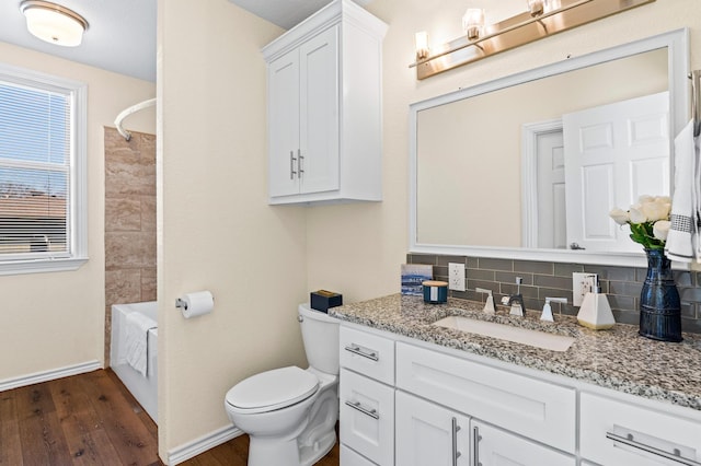 full bathroom featuring hardwood / wood-style floors, vanity, decorative backsplash, shower / bathtub combination, and toilet