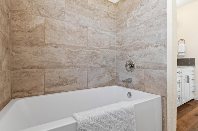 bathroom with hardwood / wood-style flooring and a bath