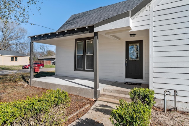 view of exterior entry featuring covered porch