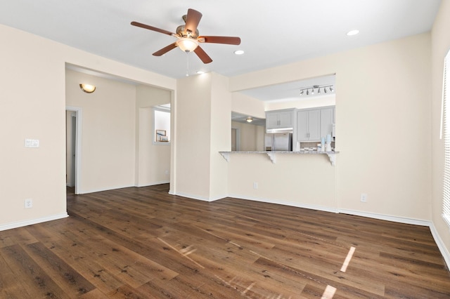 unfurnished living room with ceiling fan and dark hardwood / wood-style floors