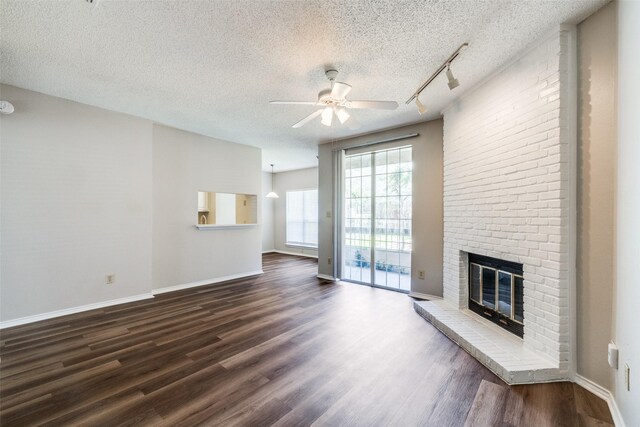 unfurnished living room featuring a fireplace, a textured ceiling, dark hardwood / wood-style floors, and ceiling fan