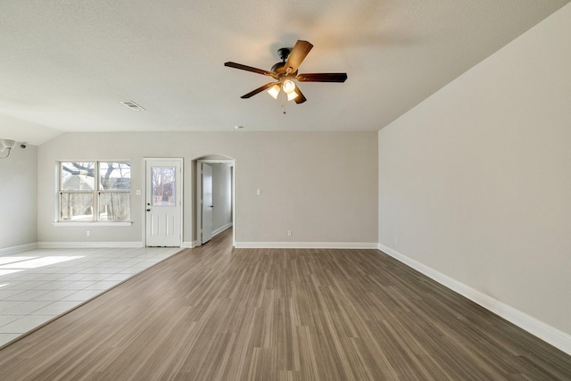 unfurnished living room with vaulted ceiling, ceiling fan, and wood-type flooring