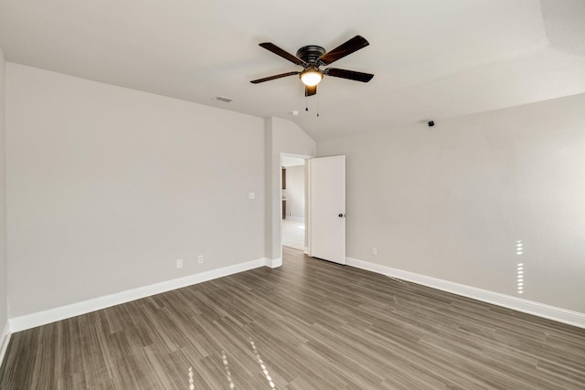 empty room featuring vaulted ceiling, dark wood-type flooring, and ceiling fan