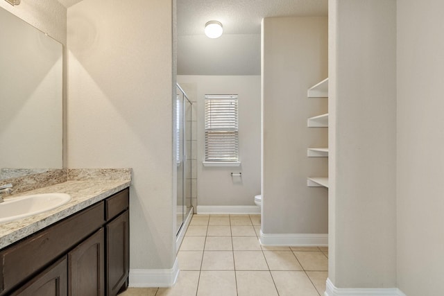 bathroom featuring toilet, tile patterned floors, walk in shower, and vanity